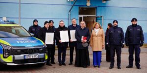 Zdjęcie przedstawia radiowóz i przedstawicieli samorządu
